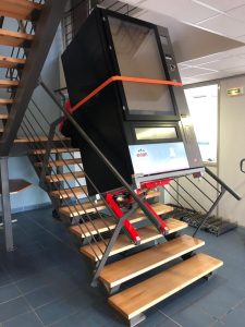 Transport eines schweren Verkaufsautomaten über einer Treppe mit dem elektrischen Treppensteiger mit Raupen Domino Automatic Stabilized